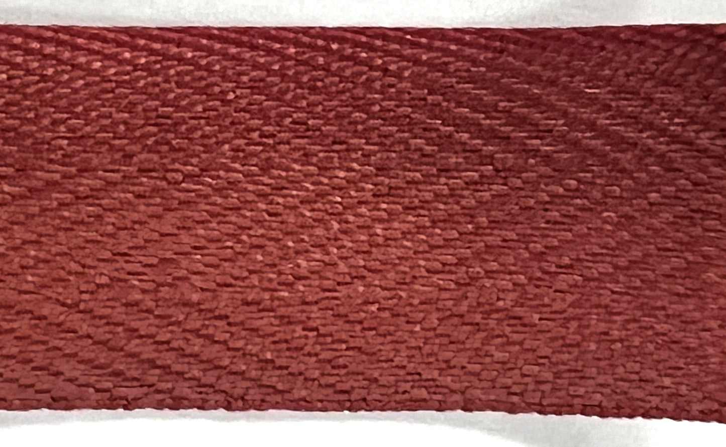 Close-up of a textured red-brown fabric strip on a white background